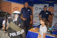 Dzieci podczas pikniku odwiedzają stoisko raciborskiej policji oglądają sprzęt i radiowóz