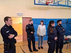 na zdjęciu policjanci stoją  na sali gimnastycznej