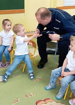 na zdjęciu policjant przybija piątkę chłopczykowi